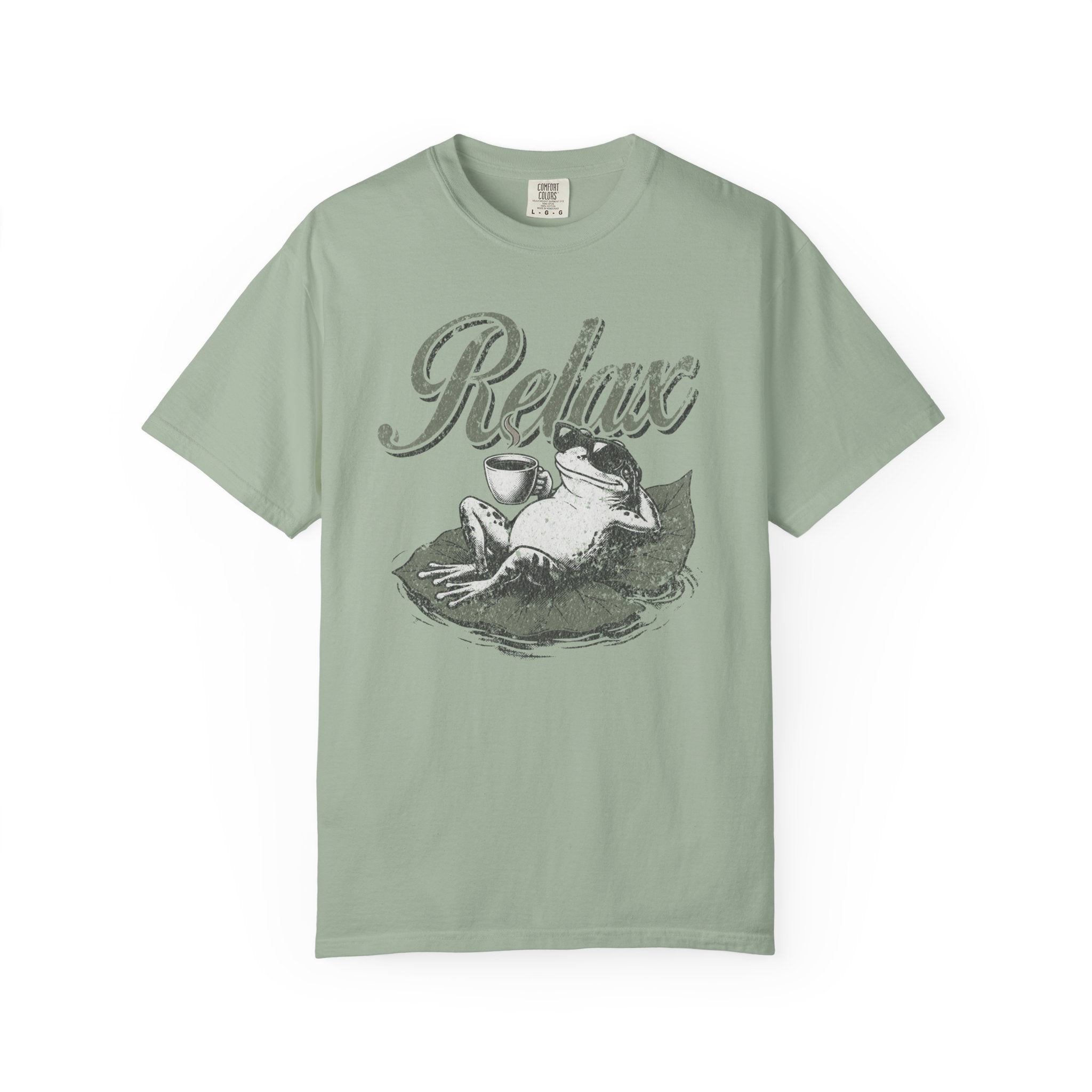 Sage green unisex t-shirt with a distressed graphic of a frog wearing sunglasses on a lily pad.
