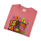 A pink t-shirt featuring a retro, psychedelic graphic of a person drinking coffee.