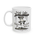 White ceramic coffee mug featuring a frog hanging from a branch above a crocodile.
