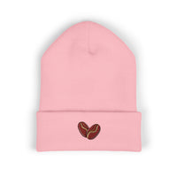 A pink cuffed beanie with two embroidered coffee beans on the cuff.