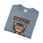 A folded blue unisex cotton t-shirt featuring a graphic of a wide-eyed kitten and the word COFFEE.