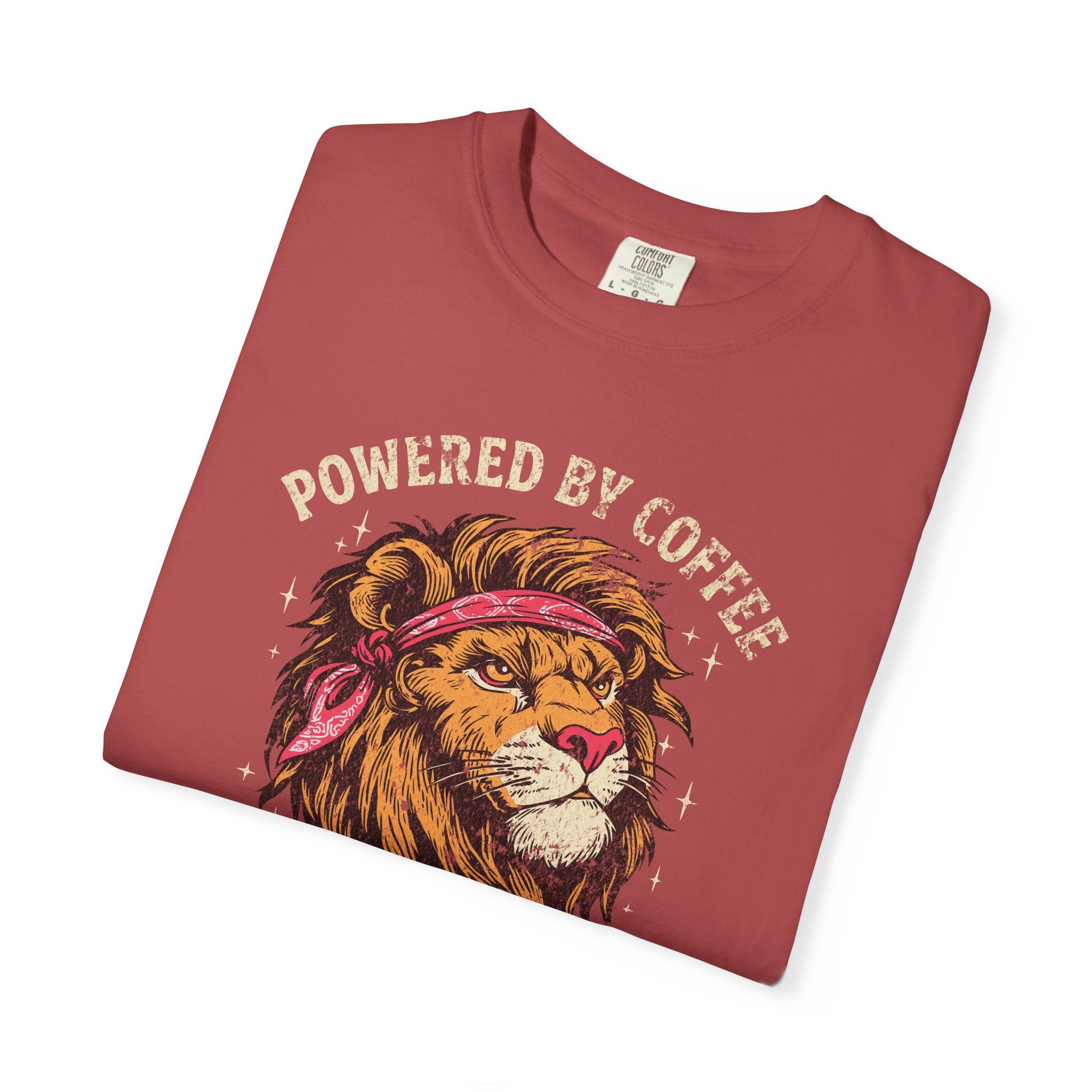 Red t-shirt with a distressed graphic of a lion wearing a bandana and the text Powered by Coffee.
