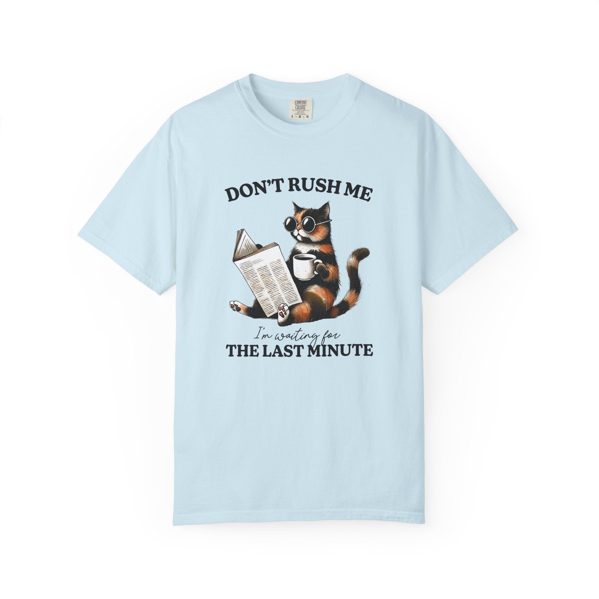 A light blue cotton t-shirt featuring a graphic of a cat wearing sunglasses, reading, and drinking.