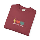 A folded crimson heavyweight cotton t-shirt featuring a peace sign, heart, and coffee cup graphic.