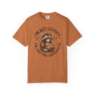 Rust-colored unisex t-shirt featuring a raccoon wearing glasses and reading a book.