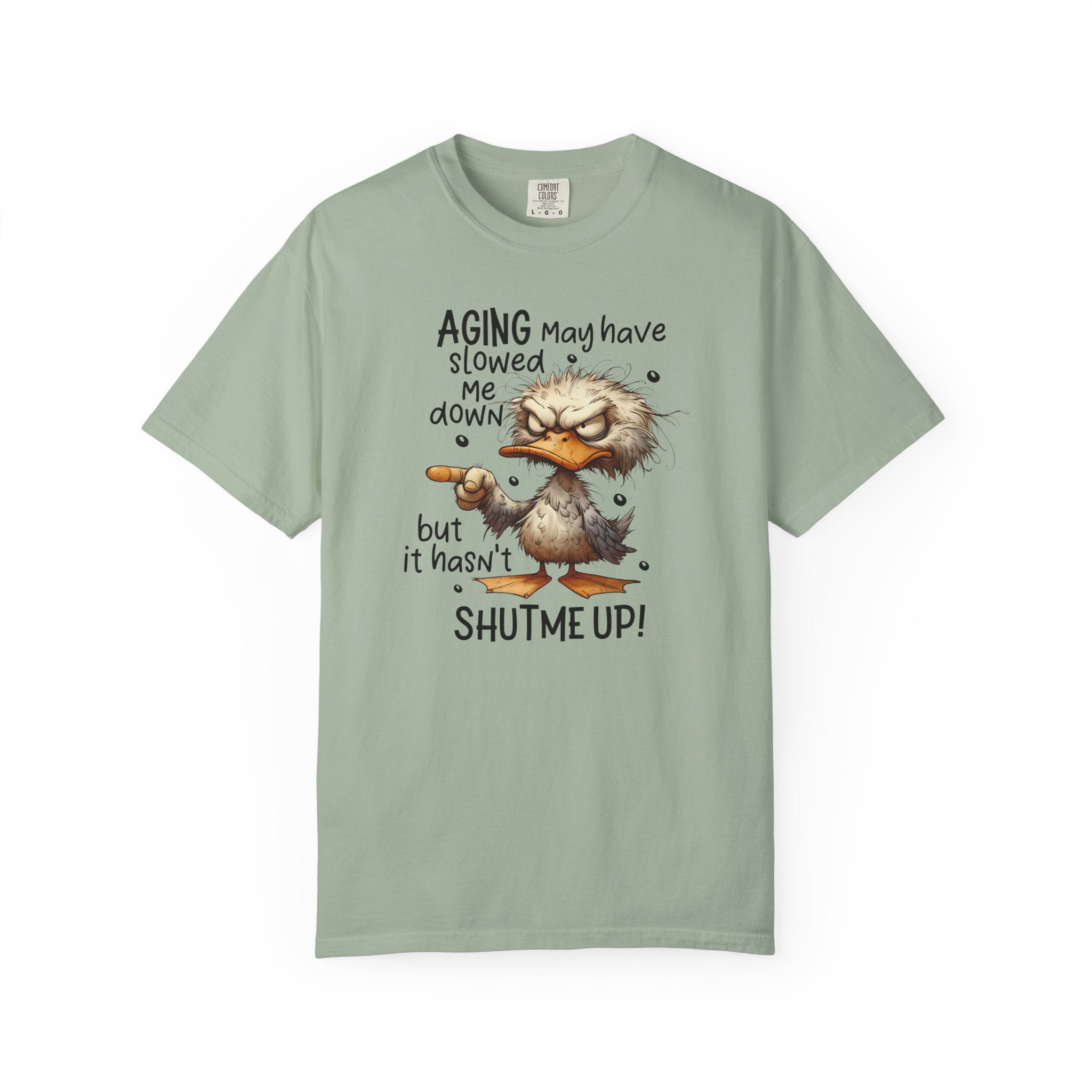 A sage green heavyweight cotton t-shirt featuring a grumpy duck graphic and humorous text.