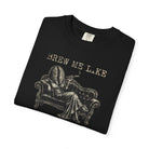 Black Comfort Colors 1717 t-shirt with a vintage-style graphic of a coffee bean person on a sofa.
