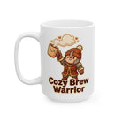A white ceramic mug featuring a cartoon warrior holding a steaming coffee cup with the text Cozy Brew Warrior.