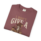 A maroon unisex cotton t-shirt featuring a graphic of a rat in a cowboy hat riding a donkey.