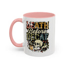 White ceramic coffee mug with a pink handle and a retro skull graphic reading Death Before Decaf.