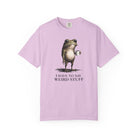 A light pink cotton t-shirt featuring a graphic of a frog holding a coffee mug with text below.