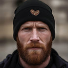 Black cuffed beanie with embroidered coffee bean heart detail.