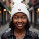 White cuffed knit beanie with an embroidered coffee cup design.