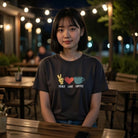 A woman wears a charcoal gray heavyweight cotton t-shirt featuring a peace sign, heart, and coffee.