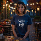 A woman wears a navy blue heavyweight graphic tee featuring the text Coffee First #Hustle Later.