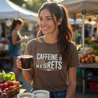 A woman wears a brown Caffeine & Zero Regrets t-shirt while holding a steaming cup of coffee.