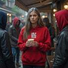 A woman wears a red Drip With Sarcasm hoodie while holding a coffee cup in a rainy outdoor setting.