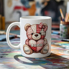 White ceramic mug featuring a patchwork teddy bear holding a heart with the word LOVE.