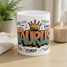 White ceramic mug featuring a bold graffiti-style Taurus design with a crown and zodiac traits.