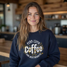 A woman wearing a navy blue sweatshirt with a Fill With Coffee For Best Results graphic.