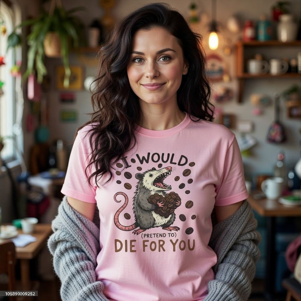 A woman wears a pink t-shirt featuring a graphic of an opossum holding coffee beans.