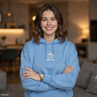 A woman wears a pastel blue fleece hoodie featuring a small white coffee cup graphic.