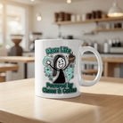 A white ceramic mug featuring a cartoon illustration of a woman surrounded by chaos and coffee.