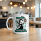 A white ceramic mug featuring a cartoon illustration of a woman surrounded by chaos and coffee.