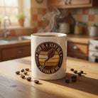 White ceramic coffee mug with a retro-style graphic of a coffee bean and humorous text.