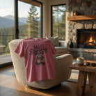Pink t-shirt featuring a raccoon wearing a cowboy hat and holding a coffee mug.
