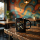 Black ceramic coffee mug with Death Before Decaf text and a skull illustration.