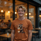 Unisex Comfort Colors 1717 cotton tee featuring a raccoon holding a coffee cup with a skull logo.