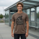 Man in a brown Coffee Slayer graphic tee with a raccoon illustration and psychedelic typography.