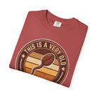 A folded red t-shirt featuring a distressed graphic of a coffee bean and the text This Is A Very Old
