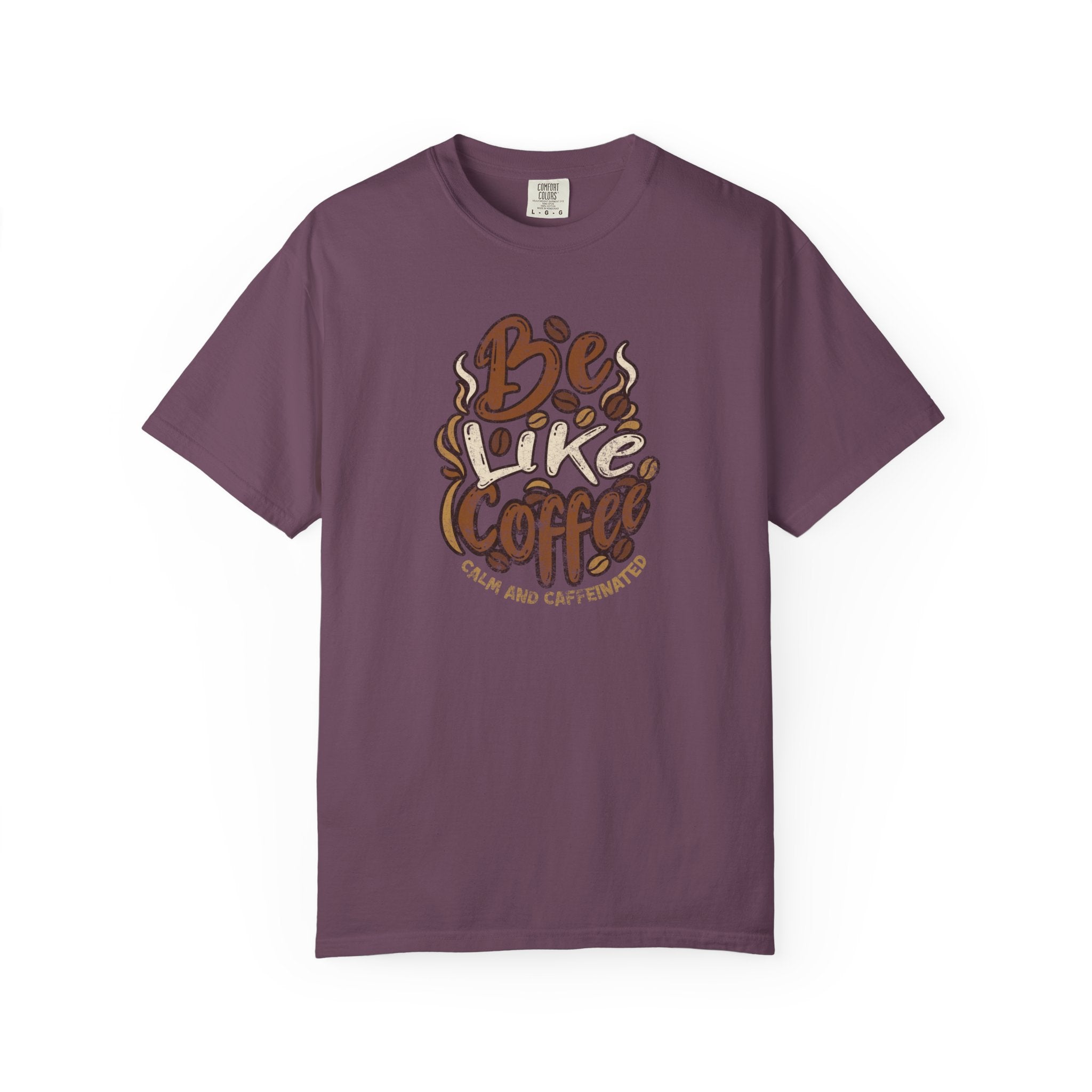 A plum-colored t-shirt featuring a distressed graphic that says Be Like Coffee Calm and Caffeinated.
