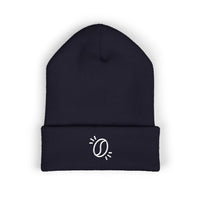 A dark navy blue cuffed knit beanie featuring a small white embroidered coffee bean graphic.