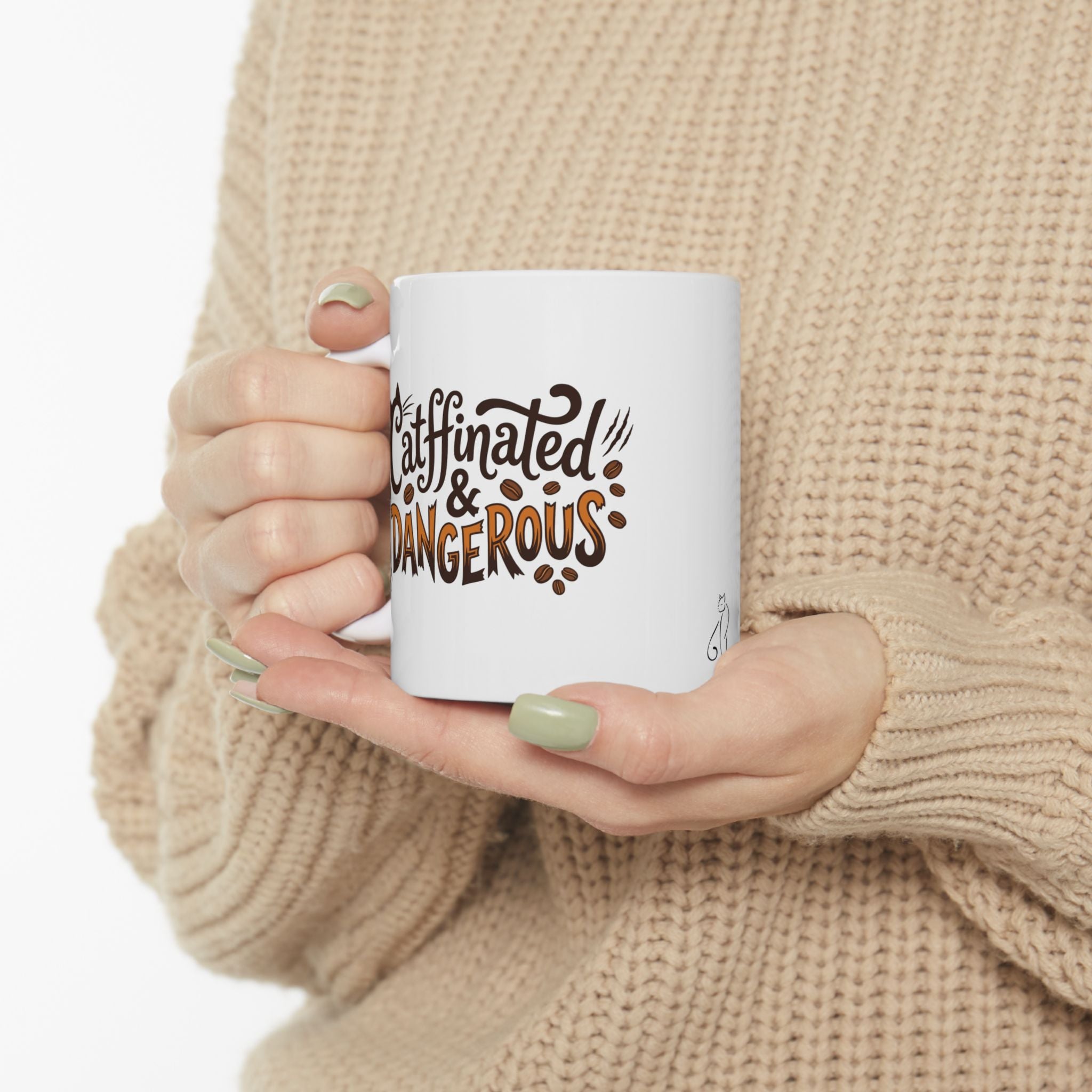 A white mug with "Catffinated & Dangerous" text and coffee beans.