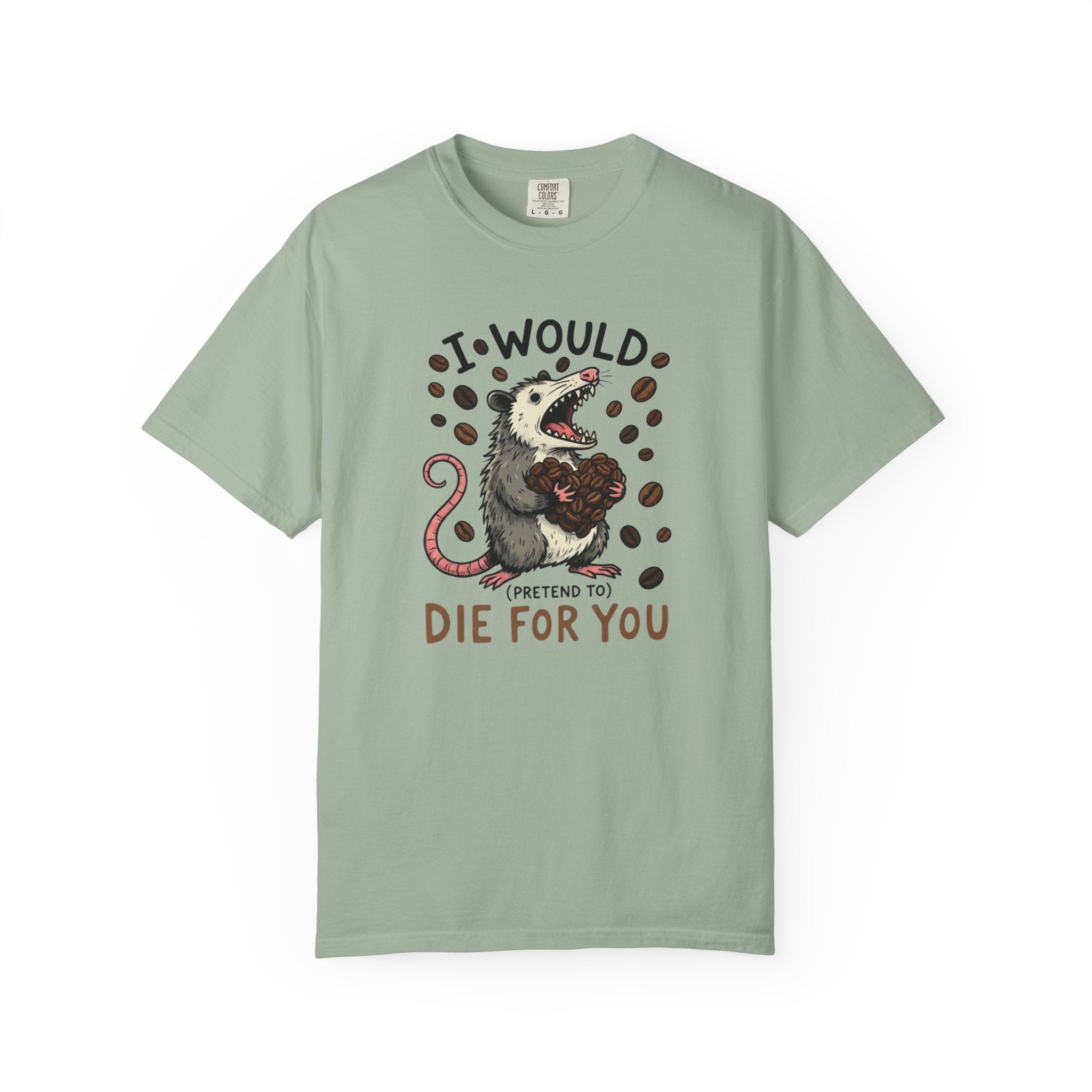 A sage green t-shirt featuring a graphic of an opossum holding a heart made of coffee beans.
