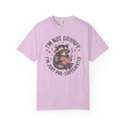 Light purple unisex t-shirt featuring a graphic of a raccoon wearing glasses and reading a book.