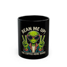 Black ceramic mug featuring a green alien wearing sunglasses and making peace signs.