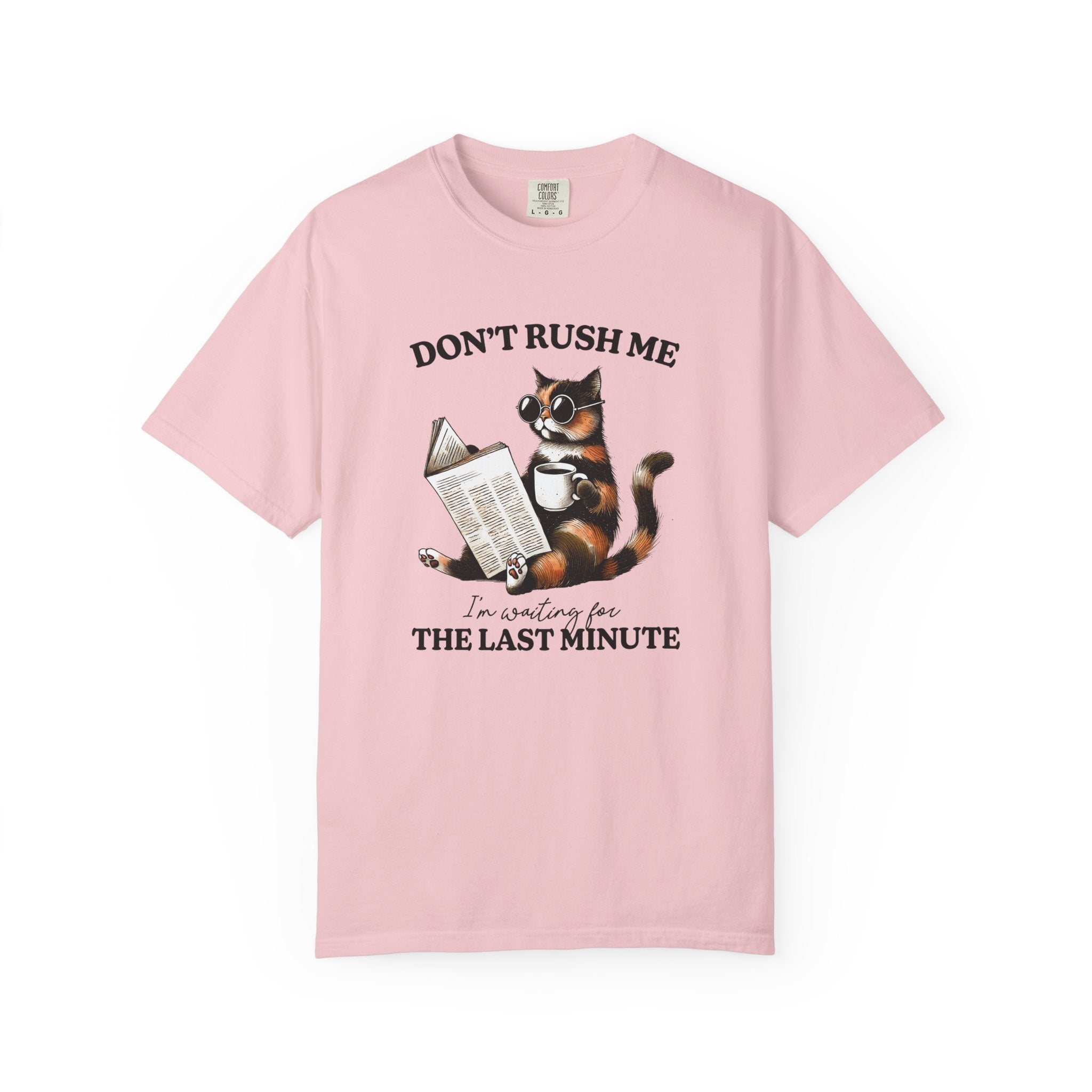 A light pink cotton t-shirt featuring a graphic of a cat wearing sunglasses, reading, and drinking coffee.