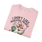 A pink t-shirt featuring a graphic of an angry duck holding a coffee mug with the text above it.