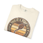 Folded cream-colored t-shirt with a vintage-style graphic of a coffee bean and text.