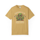 Mustard yellow unisex t-shirt with a distressed graphic of an alien making peace signs with coffee.