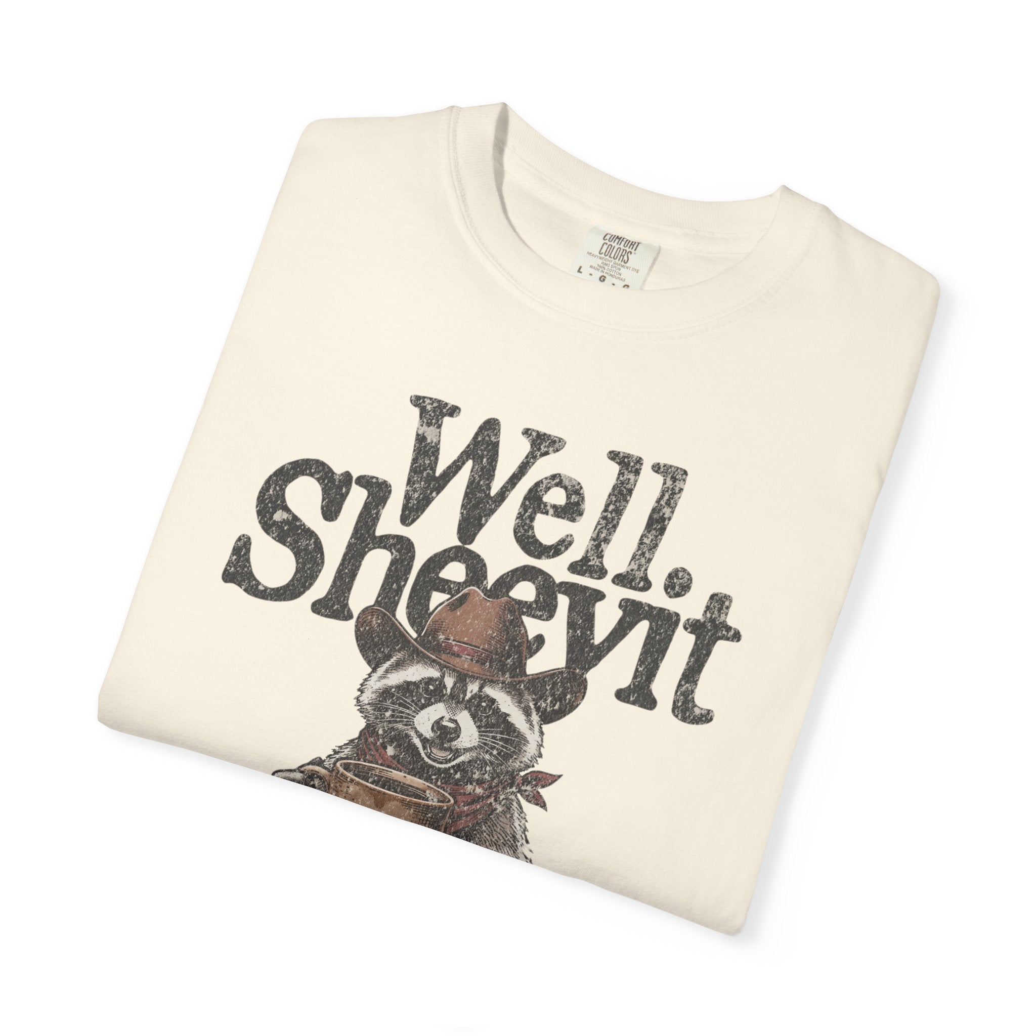 Cream-colored t-shirt featuring a distressed graphic of a raccoon in a cowboy hat holding coffee.