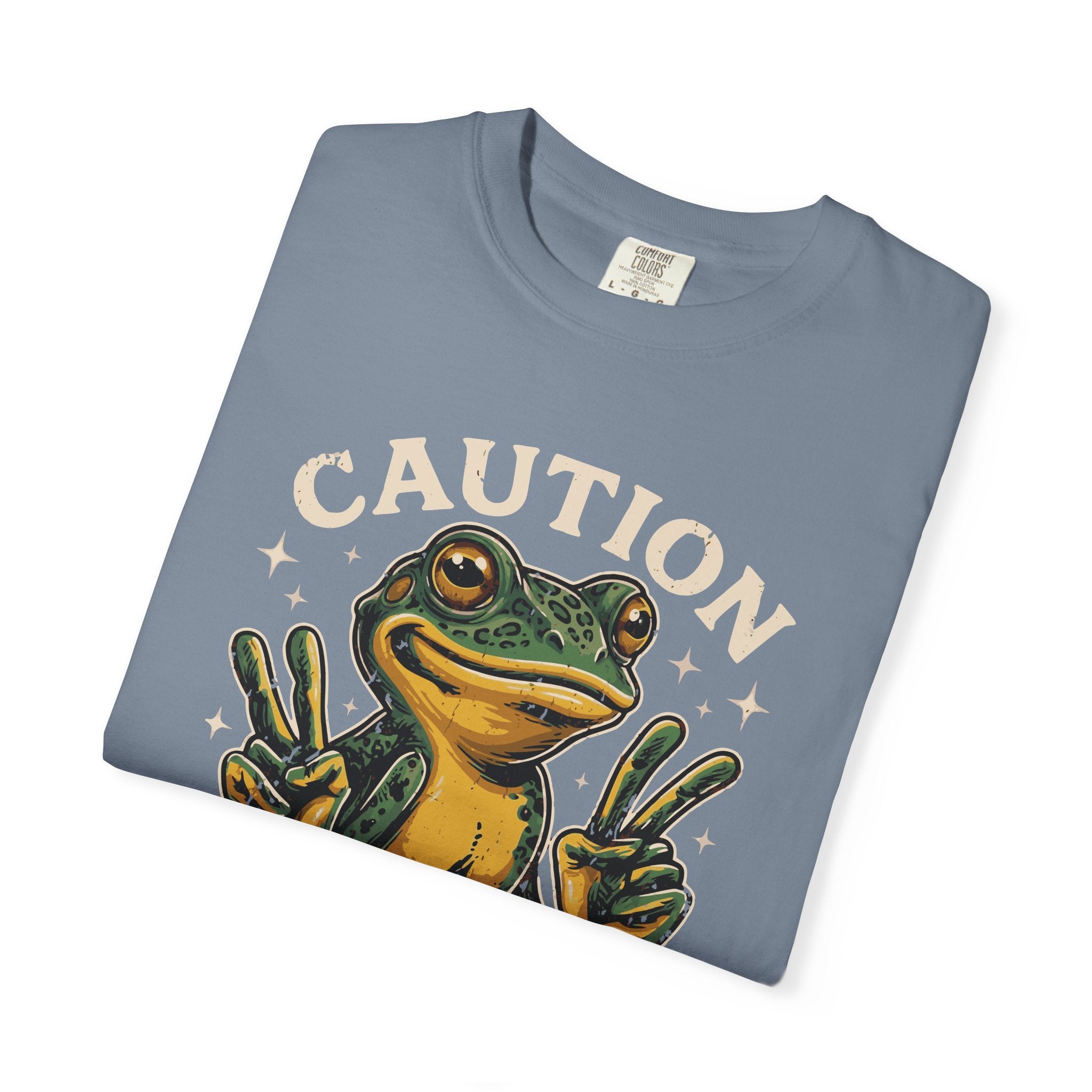 Blue t-shirt featuring a graphic of a frog making peace signs with the word CAUTION above it.