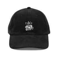 Black corduroy baseball cap with an embroidered white coffee cup and heart logo.
