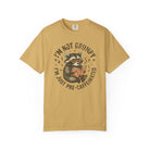 Mustard yellow unisex t-shirt featuring a raccoon wearing glasses and reading a book.