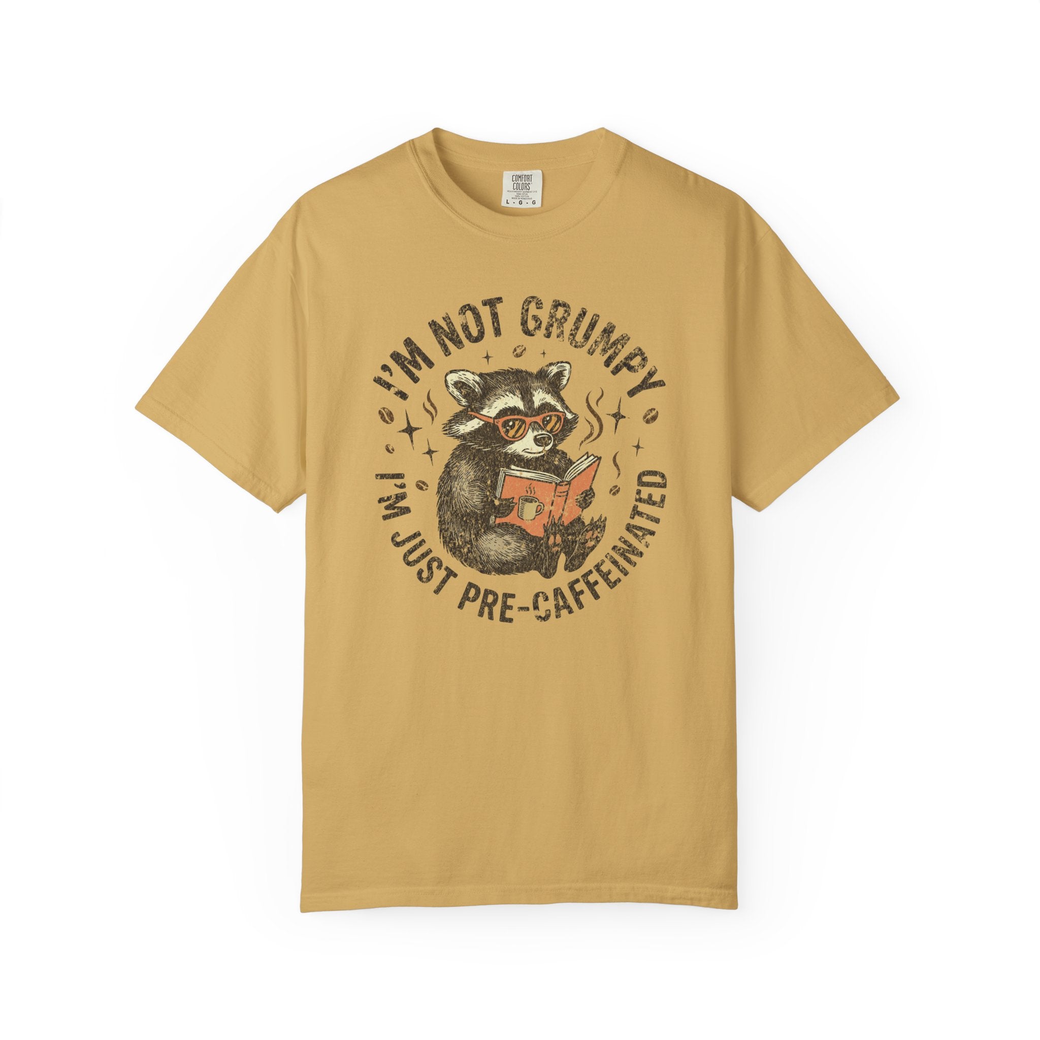 Mustard yellow unisex t-shirt featuring a raccoon wearing glasses and reading a book.