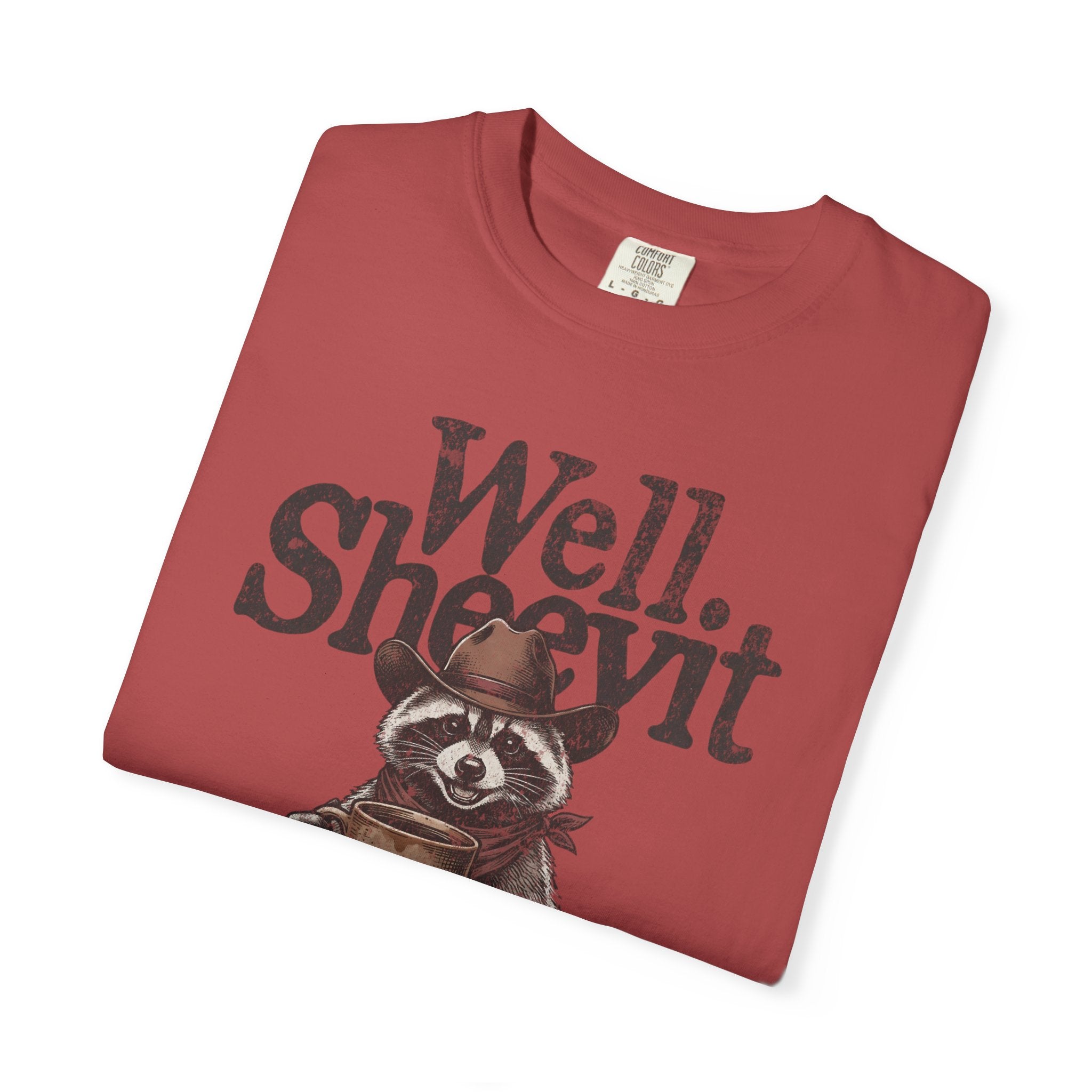 Red t-shirt featuring a graphic of a raccoon in a cowboy hat holding a coffee mug.